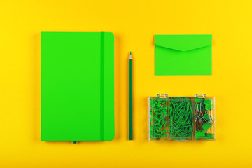 Green stationery flat lay over yellow