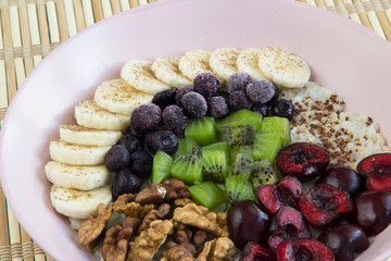 Oatmeal with banana, cherries, kiwi, blueberries, walnuts