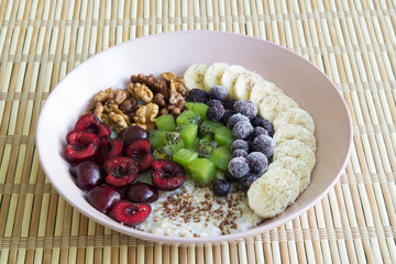 Oatmeal with banana, cherries, kiwi, blueberries, walnuts