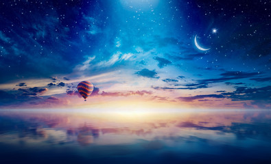 Crescent and hot air balloon rising above serene sea in sunset glowing sky - Powered by Adobe