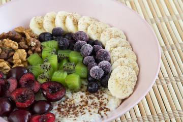 Oatmeal with banana, cherries, kiwi, blueberries, walnuts