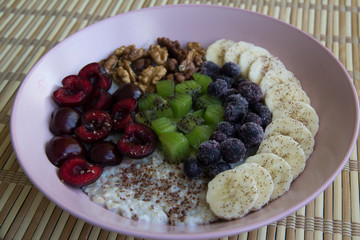 Oatmeal with banana, cherries, kiwi, blueberries, walnuts