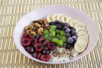 Oatmeal with banana, cherries, kiwi, blueberries, walnuts