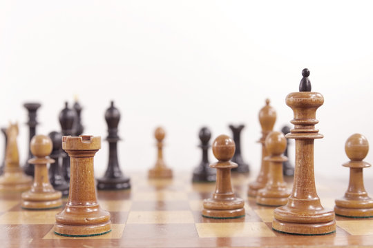 Chess game. Old wooden chessmen on the chess board on white background. Interesting moment of a game of chess Tal - Geller in the International Chess Tournament in Zurich, 1959