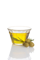 glass bowl of fresh olive oil with green olives