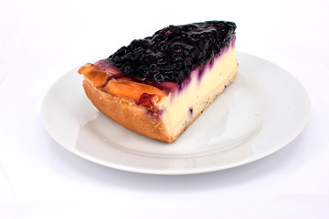 Ein Stück Käsekuchen mit Blaubeeren auf weißem Teller, isoliert vor weißem Hintergrund, von...