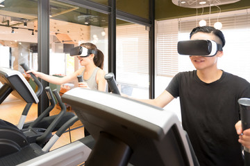 クロストレーナーで運動をする男女（VRゴーグル着用）
