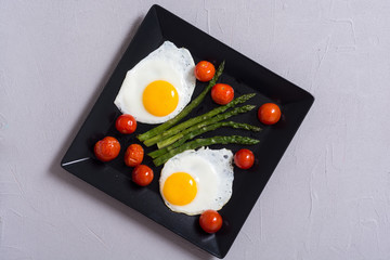 Healthy breakfast with eggs , asparagus and tomatoes
