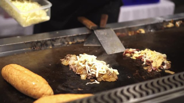 Adding cheese in Philly's cheesesteak sandwich at festiva