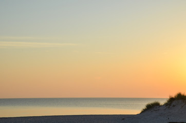 Colorful sky by a sandy beach by sunset