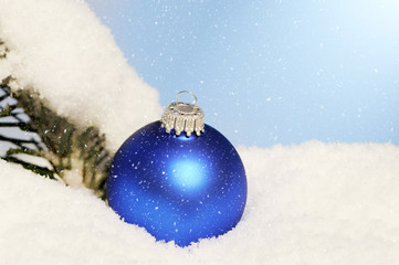blue christmas ornament lying in snow © Caro