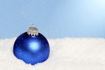  blue christmas ornament lying in snow © Caro