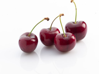 cerezas cuatro con rabo sobre fondo blanco. four cherries with tail on white background.