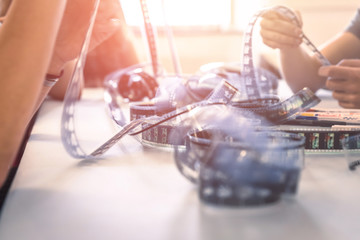 Cinema film reel on a cutting table: Filmmaker is working with vintage film strip