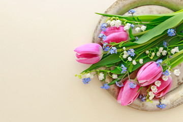 Bouquet of pink tulips, lily of the valley and forget me not flowers.