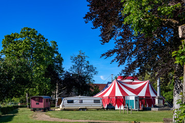 Carpa del circo con sus caravanas al lado en un pequeño pueblo