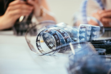 Cinema film reel on a cutting table: Filmmaker is working with vintage film strip