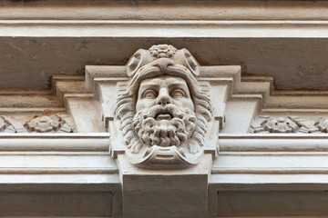 head of a man with a beard on the facade of an old building. architectural detail - mascaron. Saint-Petersburg, Russia