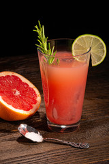 Grapefruit-Cocktail mit Limette, Zucker, Löffel und Rosmarin