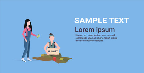 girl giving money to sad woman beggar holding sign board with hungry text girl tramp begging for help homeless concept flat full length horizontal copy space