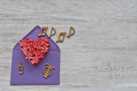 Envelope with heart and music note on wooden background 