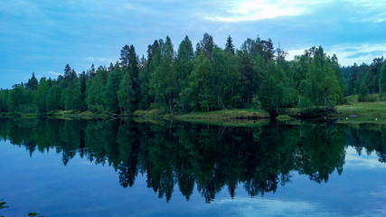 reflection of trees in the river water in Oulu, Finland
