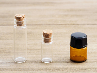 Three glass bottles for aromatherapy products on wooden background