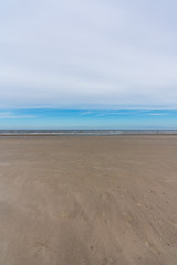 Fototapeta na wymiar Sandstrand am Meer mit Wolken