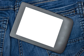 An e-reader hidden in a pocket of jeans pants. Close-up with selective focus. Copy space. Training and technology concept