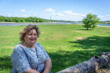 Mature woman tourist sitting on a log