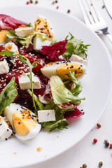 Fresh mixed salad in a bowl on a white background