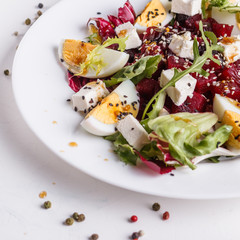 Fresh mixed salad in a bowl on a white background