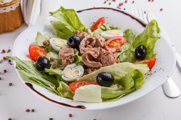 Fresh salad with iceberg lettuce,tomatoes,eggs,canned tuna and olives