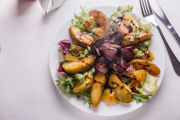 Baked potatoes with boiled chicken liver on a plate