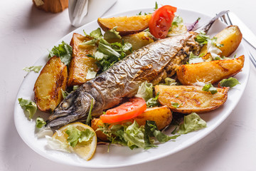 Baked stuffed fish with potatoes on the plate