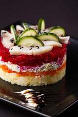 Russian salad herring under fur coat on a dark background