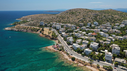 Aerial drone photo of famous seaside village of Varkiza with deep turquoise sandy beaches and clear blue sky, Athens riviera, Attica, Greece