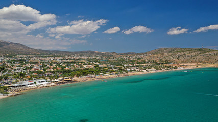 Fototapeta na wymiar Aerial drone photo of famous seaside village of Varkiza with deep turquoise sandy beaches and clear blue sky, Athens riviera, Attica, Greece
