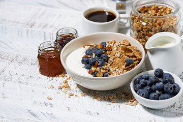 bowl of healthy wholegrain flakes, natural yogurt and fresh blueberries for breakfast