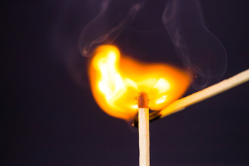 Close up Macro shot of a ignition match on a second match captured in super slow motion