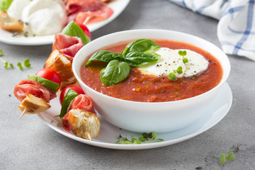 Tomato cold gazpacho soup with vegetables, mozzarella, salami, croutons and basil. Traditional...
