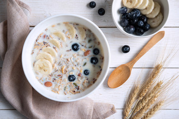 Bowl of granola almond and grains with blueberry and banana on wooden table, Healthy breakfast