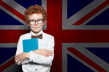 Smiling child boy student on the UK flag background. Learn English concept