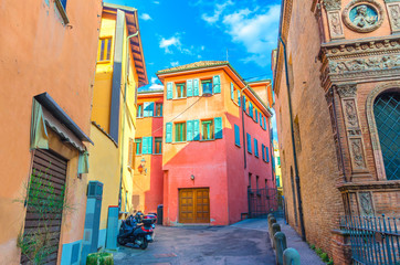 Typical italian yard, traditional buildings with colorful bright walls and bikes on the street in old historical city centre of Bologna, Emilia-Romagna, Italy