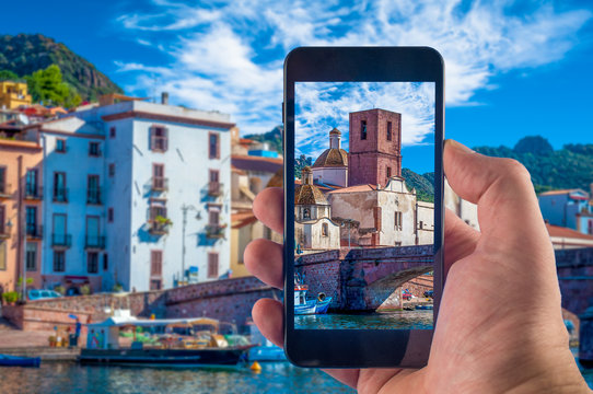 Hand taking picture with a smartphone in the village of Bosa, in Sardinia, in summer