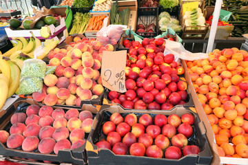 stand at market and boxes of peaches with price tag