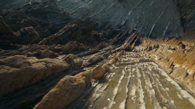 Low camera moves backs down rock slippery formations
