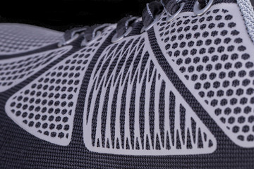 Fragment of black and white cloth sneaker. The texture of the material of sports shoes