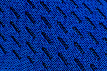 Fragment of a blue cloth sneaker. The texture of the material of sports shoes