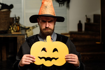 Helowin scenery for the holiday. Man holding a carved pumpkin. Party on October 31. Scary...